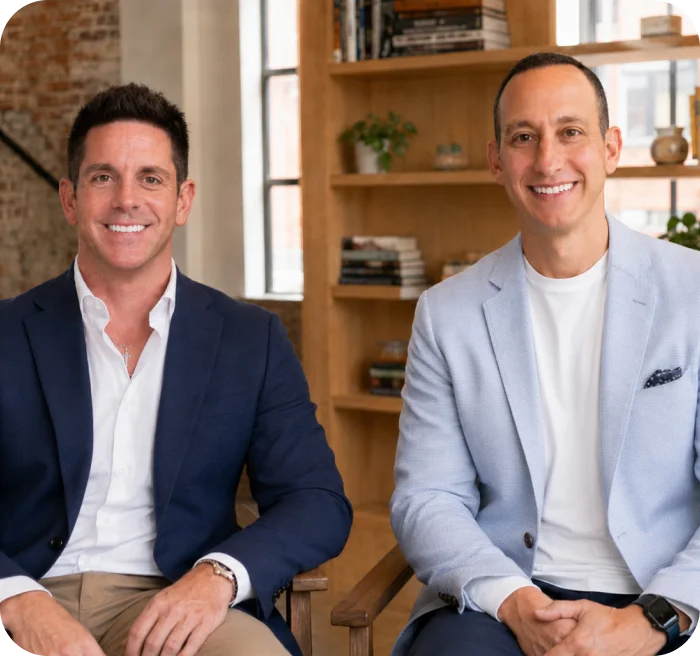 HomeVault co-founders seated in armchairs in the loft office
