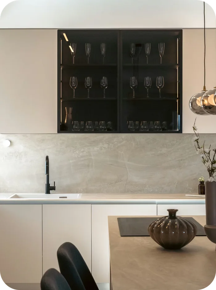 A modern kitchen with a stone backsplash, pendant lighting and an island